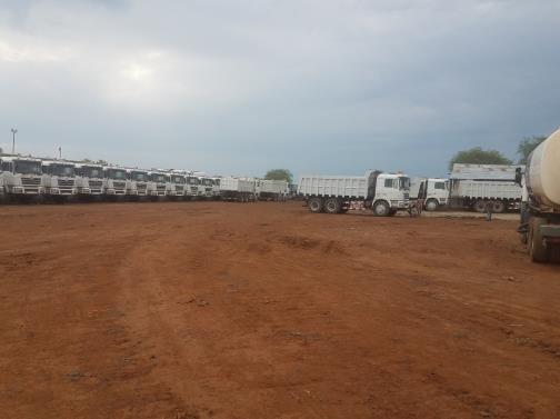 Line-up of Eagle Construction heavy plant and trucks at a site yard